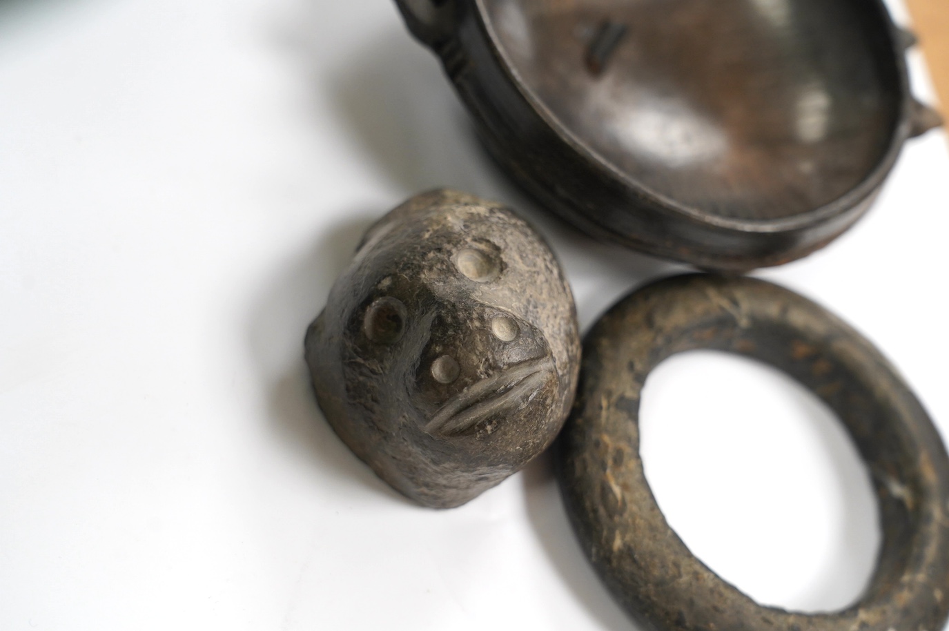 An African Dogon tribe carved stone bracelet, 10cm diameter, an Ethiopian black glazed terracotta bowl, 11cm diameter, Gurage people, and a carved black stone head of a monkey, 5.5cm, possibly North American. Condition -